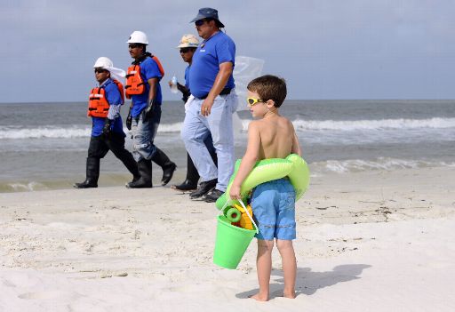 Nach der Ölkatastrophe: Am Strand von Dauphin Island, Alabama, schaut ein Junge den Arbeitern zu