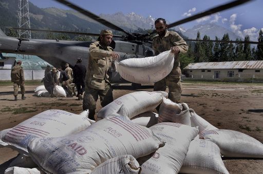 Pakistanische Soldaten laden Nahrungsmittel aus einem Hubschrauber der US Navy