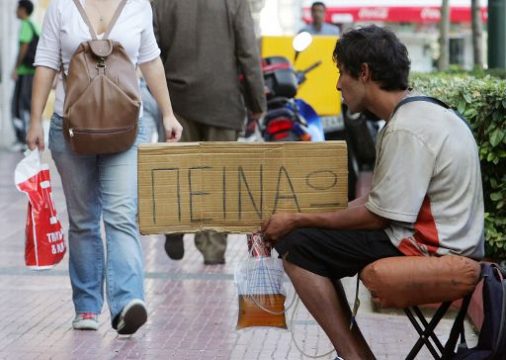 Athen, Oktober 2010: Ein Bettler hält ein Schild 'Ich habe Hunger'