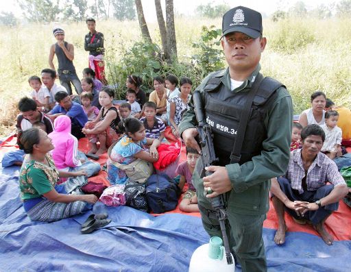 Thailändischer Grenzpolizist mit birmanischen Flüchtlingen