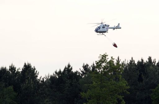 Ein Hubschrauber überwacht die Brandgebiete