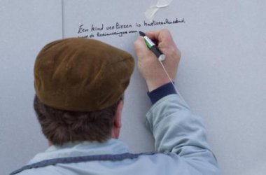 Mann unterschreibt Gedenkmauer