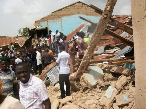 Menschen versammelten sich vor der durch einen Bombenanschlag zerstörten Kirhe in Jos