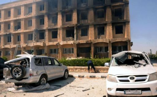 Ein ausgebranntes Haus und zerstörte Autos in Aleppo