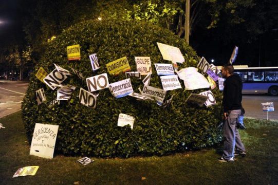 Demonstrant steckt Plakate in Busch in Madrid