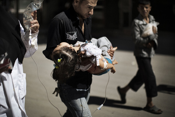 Ein Mann trägt seine verwundete Tochter aus dem Krankenhaus (Aleppo, 18. September)