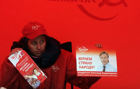 Wahlkampf-Mitarbeiterin verteilt Werbezettel für die Kommunistische Partei