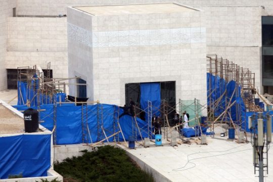 Arbeiter entfernen Teile der blauen Plastikplanen rund um das Mausoleum in Ramallah