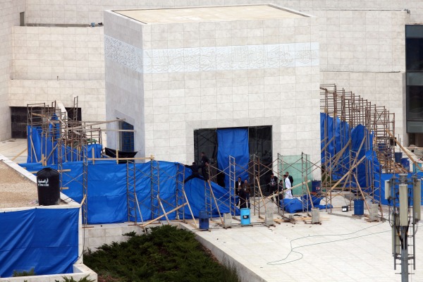 Arbeiter entfernen Teile der blauen Plastikplanen rund um das Mausoleum in Ramallah