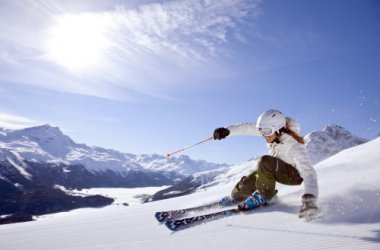 Skifahrerin im Skigebiet Corviglia mit Blick auf den gefrorenen Silvaplanersee