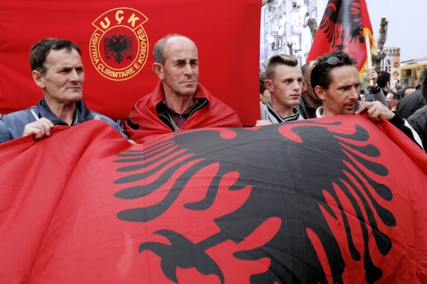 Kosovo-Albaner mit der albanischen Flagge (Hintergrund: Flagge der Befreiungsarmee UCK)