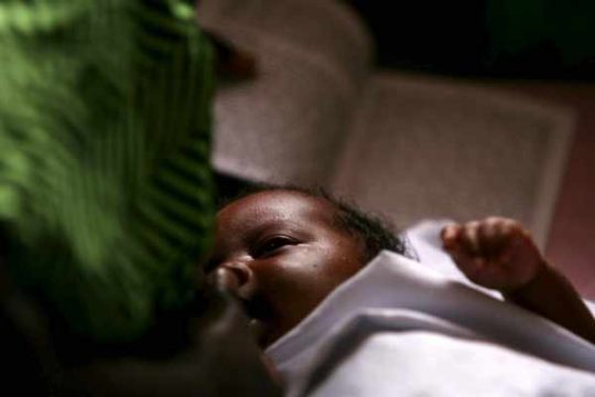 Mutter nährt ihr behindertes Kind in einem Krankenhaus in Kongo