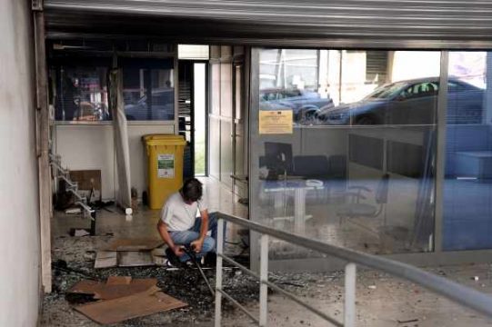 Brandanschläge in Athen - Arbeiter untersucht das Ausmaß