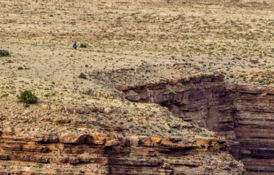 Nik Wallenda auf dem Seil an und kniet, um stärkere Schwankungen des Seils zu bremsen