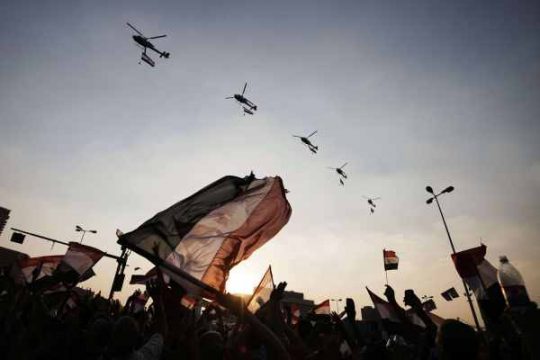 Ägypter schwenken die ägyptische Flagge während Hubschrauber der Armee über dem Tahrir-Platz in Kairo fliegen