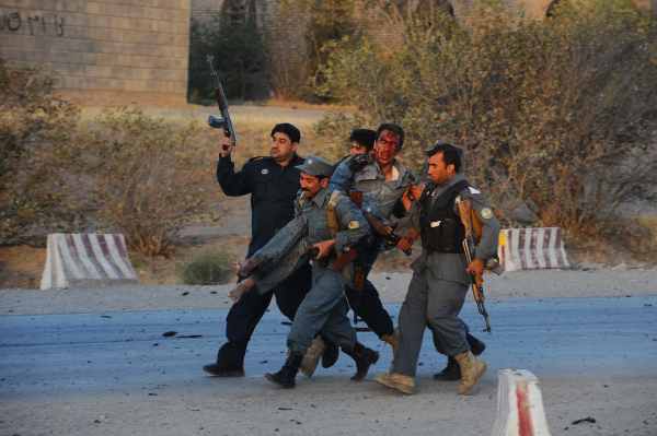Selbstmordanschlag auf US-Konsulat in Herat - afghanische Polizisten bringen verletzten Kollegen in Sicherheit