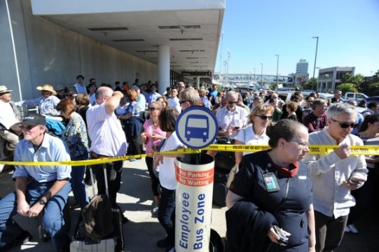 Nach den tödlichen Schüssen am Flughafen von Los Angeles - Passagiere warten hinter einer Polizeiabsperrung