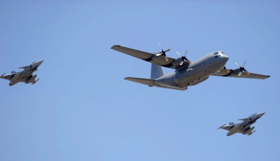 Die Militärmaschine mit dem Sarg von Nelson Mandela umgeben von von zwei Kampfjets