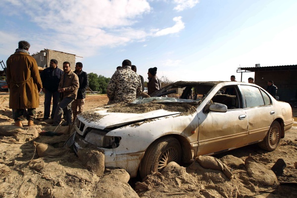 Mitglieder der libyschen Sicherheitskräfte untersuchen das an einem 60 Kilometer östlich von Bengasi liegenden Armee-Kontrollpunkt explodierte Auto