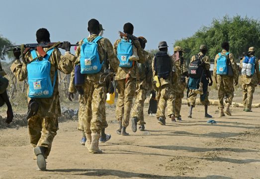 Regierungstruppen in Uniform mit Kinder-Rucksäcken von Unicef