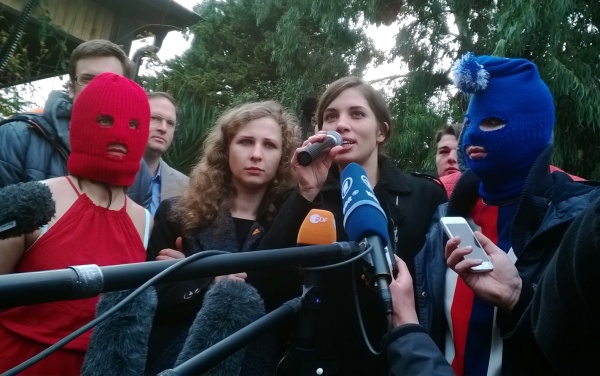 Maria Aljochina und Nadeschda Tolokonnikowa mit vermummten Mitgliedern von Pussy Riot