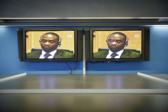 Germain Katanga auf Bildschirmen im Presseraum des Internationalen Strafgerichtshof in Den Haag