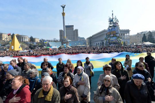 Demonstranten mit der Ukraine und der Krim-Flagge auf dem Unabhängigkeitsplatz in Kiew singen die ukrainische Nationalhymne