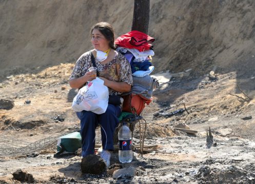 Valparaiso: Eine Frau mit ihren Habseligkeiten wartet auf Hilfe
