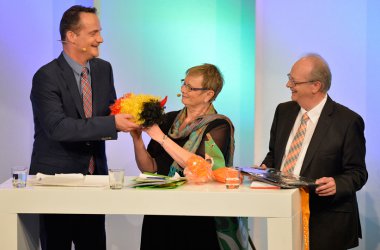 Oliver Paaschs Geschenk an Franziska Franzen: eine Belgien-Perücke "... leider kein grün dabei!"
