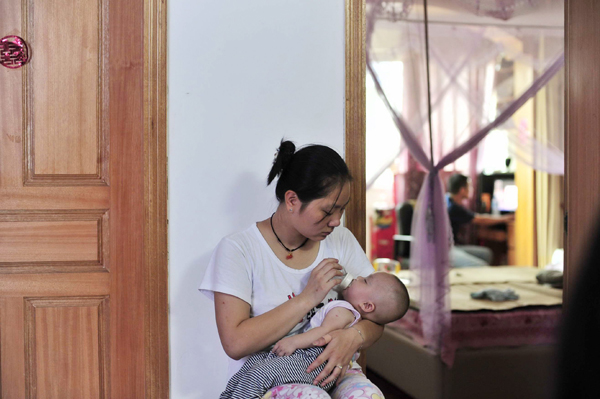 Chinesische Mutter mit ihrem Baby in der Stadt Wuhan, Zentralchina (12.8.2010)