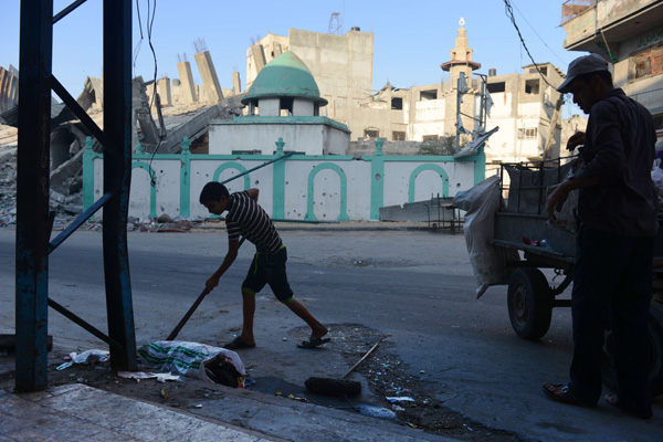 Vater und Sohn räumen Müll von der Straße (Jabalia, im Norden des Gazastreifens)