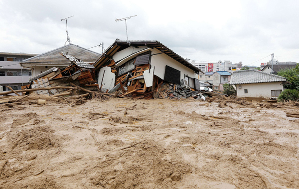 Von Schlamm umgebene zerstörte Häuser im japanischen Hiroshima