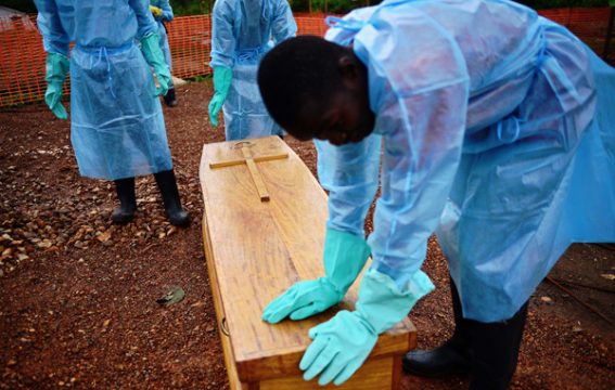 Kailahun, Sierra Leone: Staatsmitarbeiter in Schutzkleidung beerdigen Dr. Modupeh Cole. Er ist der zweite Arzt in dem Land, der an Ebola starb