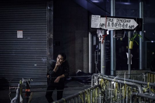 Mann neben einer Barrikade im Geschäftsviertel Mong Kok in Hongkong