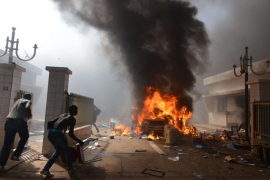 Demonstranten stürmen das brennende Parlamentsgebäude in Ouagadougou, Burkina Faso