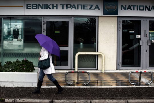 Frau vor einer Filiale der National Bank of Greece