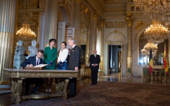 Der spanische König Felipe trägt sich ins Gästebuch ein, daneben Königin Mathilde, seine Frau Letizia und König Philippe