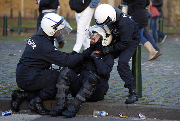 Polizisten kümmern sich um einen Kollegen, der am Rande der Großdemonstration in Brüssel verletzt wurde