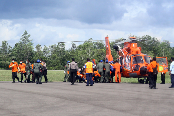 Indonesische Rettungskräfte entladen Taschen mit Leichen der verunglückten AirAsia-Maschine (24.1.)
