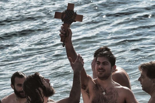 Griechische Schwimmer mit einem hölzernen Kreuz erinnern an die Taufe Jesu und die Erscheinung des Heiligen Geistes (Epiphaniasfest)