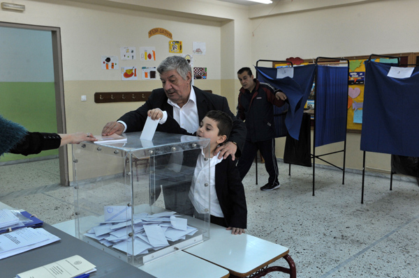 Grieche mit seinem Sohn bei der Stimmabgabe in Thessaloniki