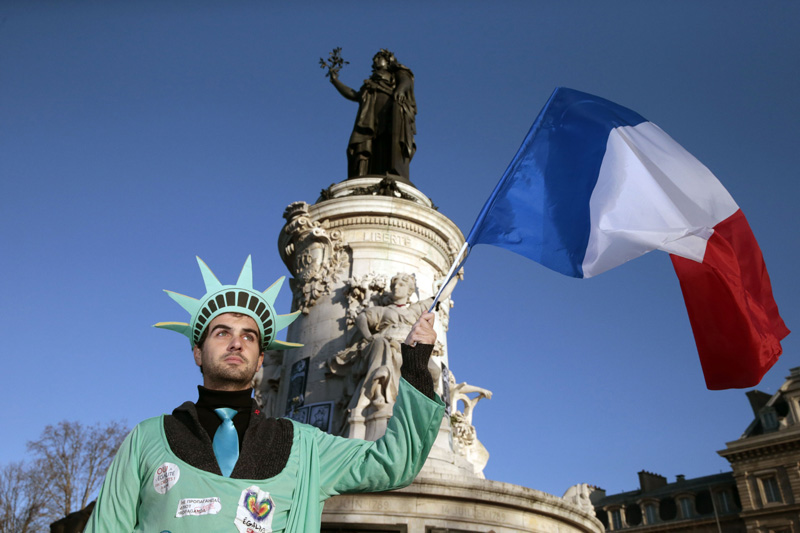 Place de la République, Paris: Ein Mann, verkleidet als Freiheitsstatue, schwenkt die französische Flagge