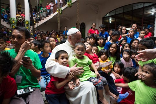 Papst Franziskus in der Arena in Manila umgeben von Kindern