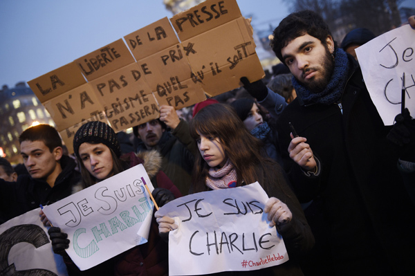 "Die Pressefreiheit hazt keinen Preis" steht auf des Plakat eines Mannes auf auf der Place de la Republique