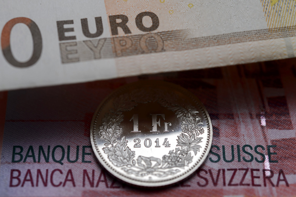 Schweizer Franken (Schein und Münze) unter einem Euro-Schein in Lausanne