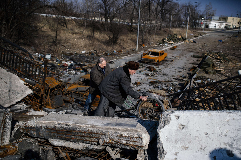 In der Nähe von Donezk: Männer schieben einen Karren über eine zerstörte Brücke