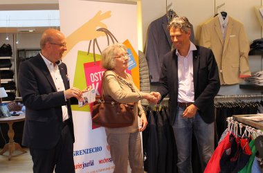 Pressekonferenz im Modehaus Pankert: Die erste Kundin erhält eine Teilnahmekarte für das Gewinnspiel