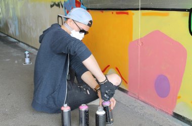 Beim Sprayen an dem Graffiti, das die Stadt in Auftrag gegeben hat
