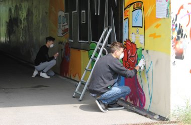 Beim Sprayen an dem Graffiti, das die Stadt in Auftrag gegeben hat