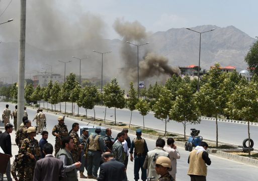 Afghanische Sicherheitsleute und Passanten beobachten den Rauch über dem Parlament in Kabul